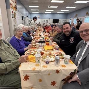 Senior citizens smile at their Thanksgiving lunch.
