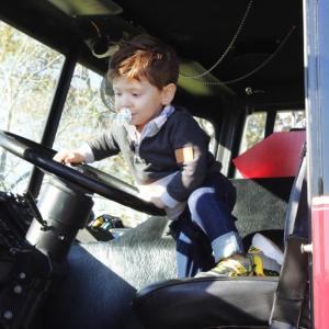 Declan Ferreira, 2, of Somerset climbs into a Mattapoisett fire truck.