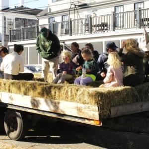 Fall fest attendees hop onto a hay ride.