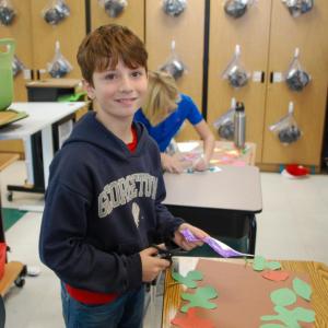 One student smiles with his craft.