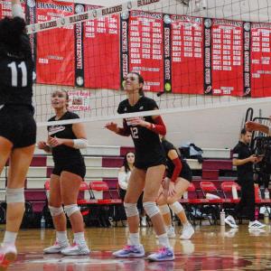 Molly Morrison, Piper Newell, and Molly Franco step up to the net to get ready for a block.
