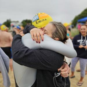 Emma Whittaker’s parents, Phil and Jess embrace after the Buzzards Bay Swim on Jun. 28. Emma’s parents continue to fundraise to support Buzzards Bay and the environment in her honor. Source: Rebecca Cusick 