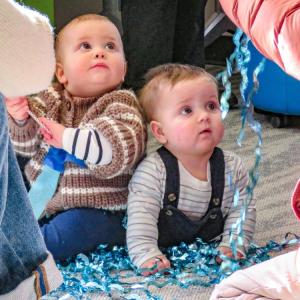Landon, 11 months,  and Marcus, 8 months, are mesmerized by shiny streamers at the Elizabeth Taber Library on Wednesday, Dec. 31. Photos by Grace Roche 