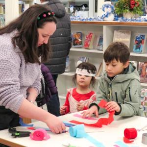 Macy Davis guides young visitors through making a streamer wand. 