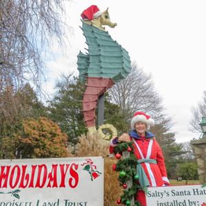 Mary Dermody poses in front of Salty the seahorse wearing the new hat she helped make. 