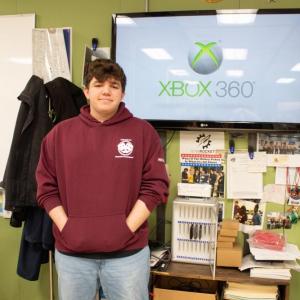 Tyler Moskos in front of his Xbox connected to a TV. 