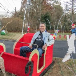Marino Carrier sits in a sleigh on his front lawn, one of the many decorations at the Mattapoisett resident's house. Photo by Grace Roche