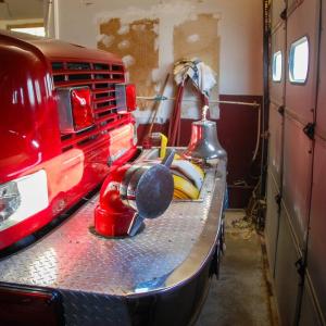 A fire truck is parked inches from the garage door.