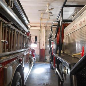 Fire engines are parked extremely close to one another.