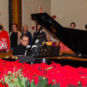 Darry Dolezal, the director, leads the group in vocal warmups.