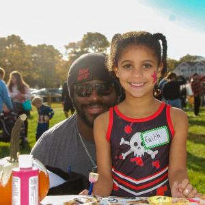 Faith, age 6, and Ray Leslie smile for a photo as they paint a pumpkin together at the Marion Trunk-or-treat. Photo by Mari Huglin 