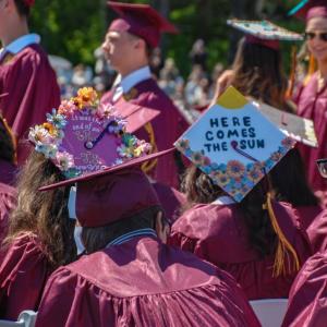 Lyrics adorn some of the graduates' caps. 
