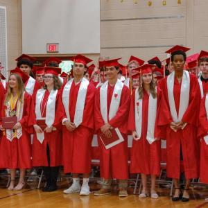 The crowd cheered as the graduating class stood together. 