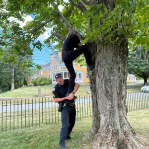 Sgt. Connor Leddin holds up Connolly as she reaches for the young animal. 