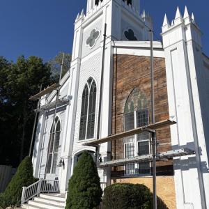 Scaffolding rises above the Rochester Church Green exposing the original 1837 rough- cut sheathing boards.
