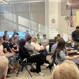 People crowded the meeting, split between attendees who supported and questioned the school's response. 
