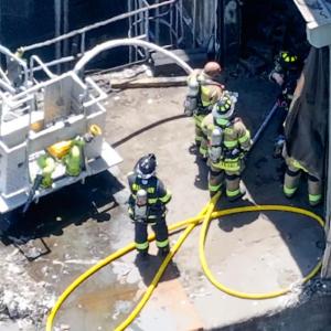 Firefighters man the hoses. 
