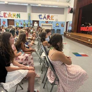 NoneSixth grade students listen as their classmate speaks during the graduation. 