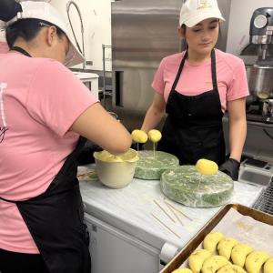 Two of the bakers set dipped pastries aside to harden. 