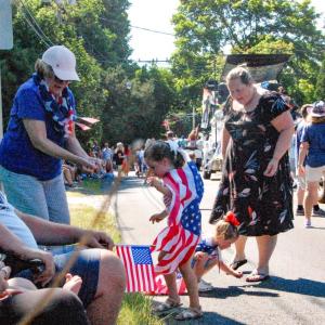 Evelyn Hussey, 6, and Valerie Hussey, 6, grab candy thrown along the parade route. 