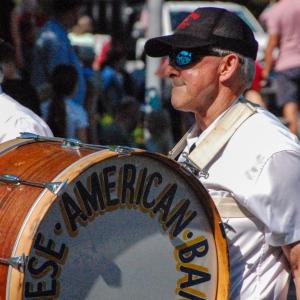 A member of the Portuguese-American Band marches down the street with his drum.