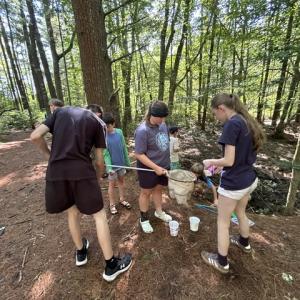 Program participants use nets and other tools to catch woodland animals. 