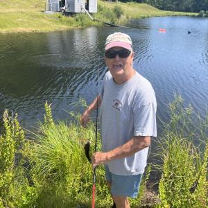 Woody Hartley holds up a bass he caught in the pond. 