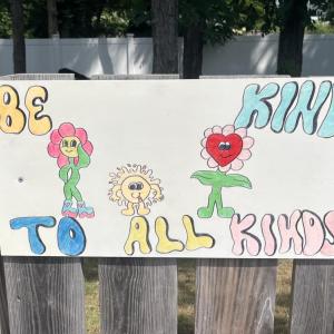 One sign features smiling flowers with a kind message. 