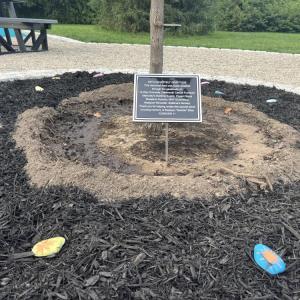 A plaque memorializes Madelyn, surrounded by painted rocks. 