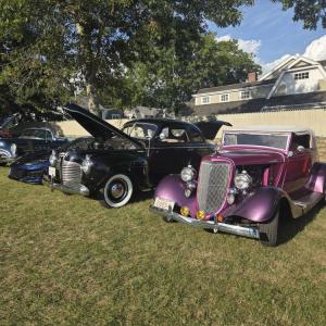 The cars were lined up in a row at the park lawn.
