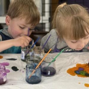 2 Children diligently painting 