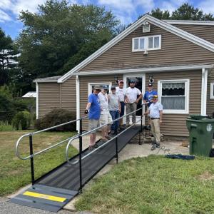 The Lions Club crew smiles around the completed ramp. 