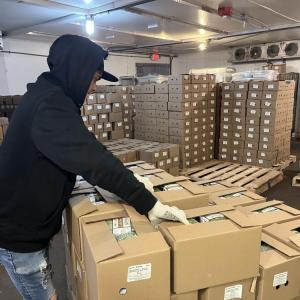 One employee prepares packages of sprouts for distribution. 