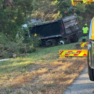 A crew drags the crashed truck out of the woods. 