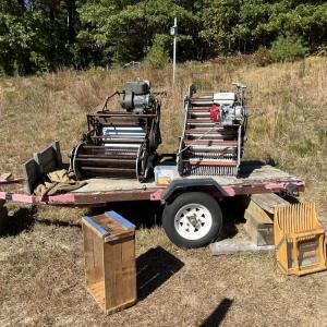 Several older pieces of dry harvesting equipment are displayed on the farm.