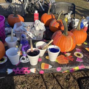 Pumpkins and paint line a table. 