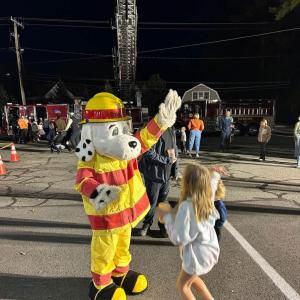 Kids high five the fire department's mascot. 